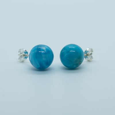 Vue de face d'une paire de boucles d'oreilles en larimar de République Dominicaine vue de face. Pierre naturelle de couleur bleu intense disponible en un seul exemplaire, modèle exceptionnel.