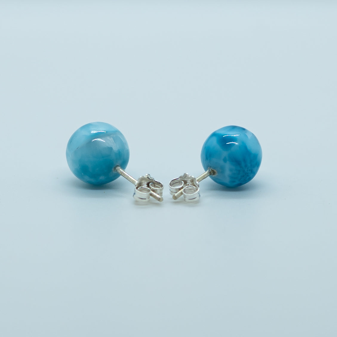 Paire de boucles d'oreilles avec une perle de larimar montée sur un tige en argent 925. Cette pierre naturelle de couleur bleue ne se trouve qu'en République Dominicaine.