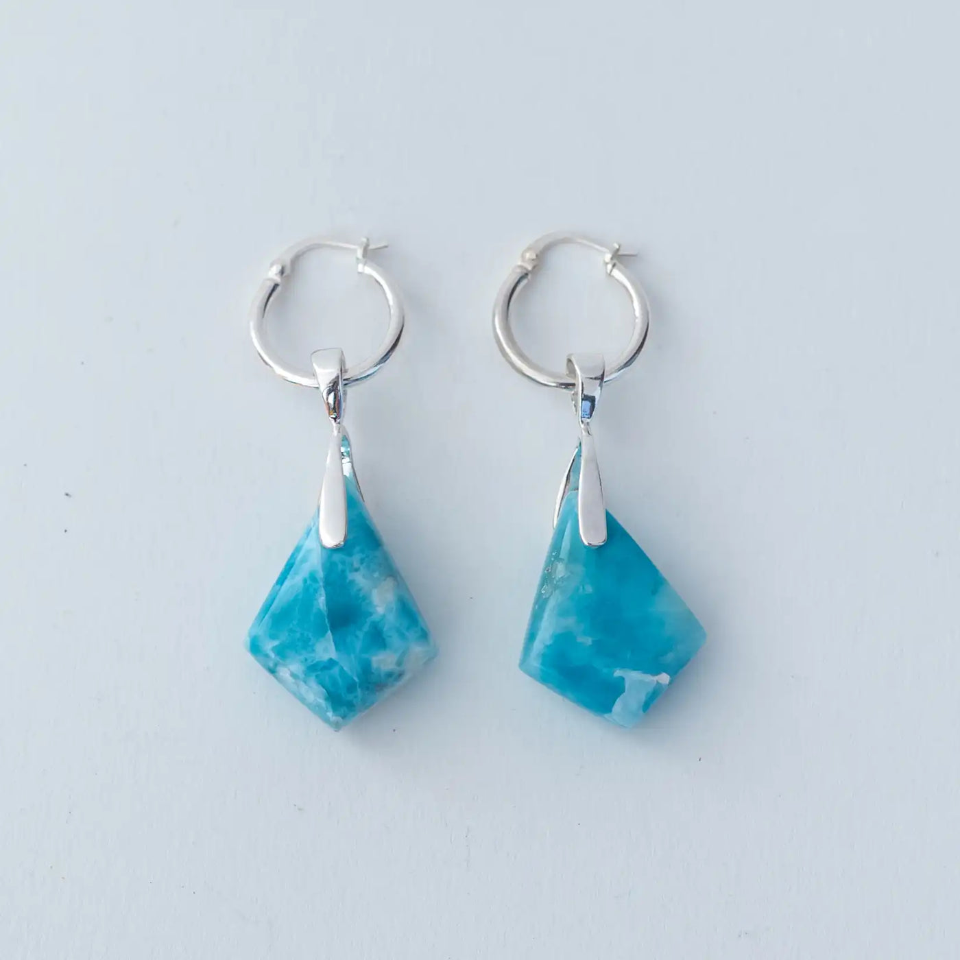 Bijoux en pierre naturelle de Larimar de couleur bleue. Boucles d'oreilles créoles en argent 925 avec deux losanges en larimar d'environ 4 centimètres de longueur.