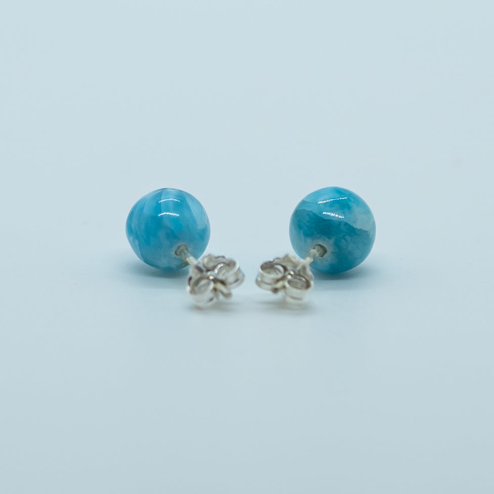 Pierre de larimar de République Dominicaine taillées en perles bleues, vue de dos, avec sur chacune un tige et un fermoir en argent 925. Bijoux fait artisanalement en République Dominicaine. Le Larimar est une pierre relaxante reliée au chakra gorge.