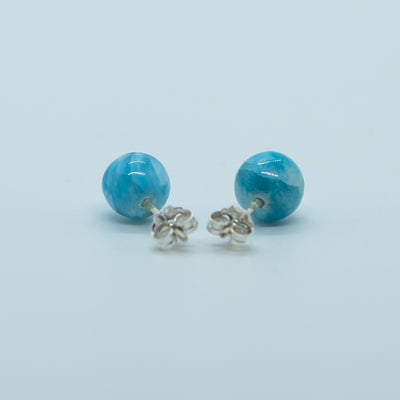 Pierre de larimar de République Dominicaine taillées en perles bleues, vue de dos, avec sur chacune un tige et un fermoir en argent 925. Bijoux fait artisanalement en République Dominicaine. Le Larimar est une pierre relaxante reliée au chakra gorge.