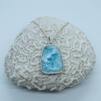 Collier en Larimar avec la face verso apparente sur la photo, cette face n'est pas serti en argent 925 comme le reste du collier pour laisser la pierre naturelle au contact de la peau.
